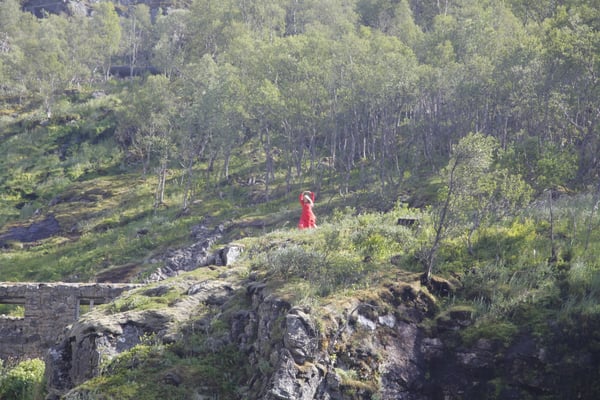 Woman in read on a hilltop in the distance