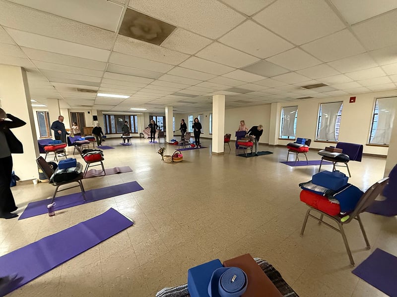 large room with linoleum floor and lots of yoga mats